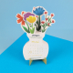 Calendrier de bureau personnalisable en forme de vase fleuri, avec fleurs multicolores en papier et logo Sintegra, présenté sur Calendrier de bureau personnalisable en forme de vase fleuri, avec fleurs multicolores en papier et logo Sintegra, présenté sur