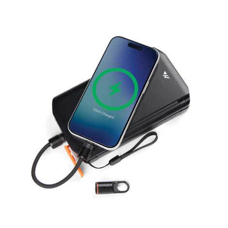 Câble de charge noir connecté à un smartphone posé sur un chargeur noir pliable, avec cordon tressé, connecteur détachable à mou