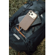 Smartphone à coque marron posé sur un chargeur noir pliable, avec câble de charge tressé branché au téléphone et mousqueton déta Smartphone à coque marron posé sur un chargeur noir pliable, avec câble de charge tressé branché au téléphone et mousqueton déta