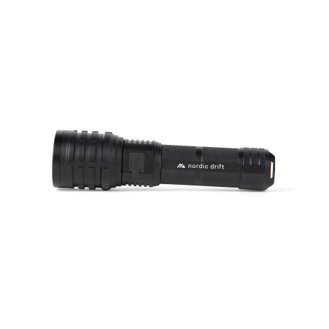Lampe torche noire présentée de profil, avec corps cylindrique à texture quadrillée, port USB protégé par un cache et extrémité 