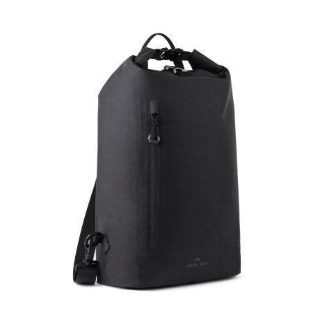 Vue de trois quarts d’un sac à dos noir avec fermeture supérieure enroulée, poche zippée verticale sur le devant et bretelles vi