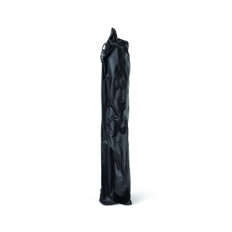 Sac de compression noir vu de profil dans sa configuration aplatie, avec matière souple plissée et valve partiellement visible s