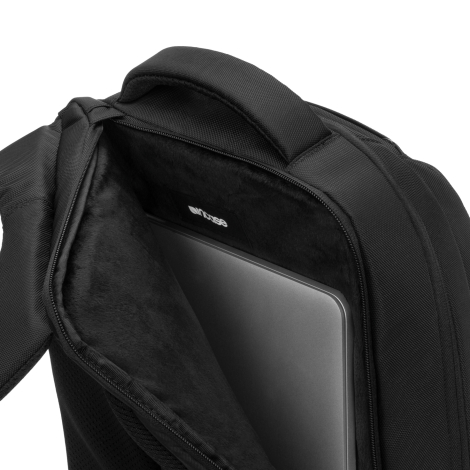 Gros plan sur le compartiment arrière du sac à dos noir, ouvert pour montrer sa doublure douce et épaisse de couleur noire, prot