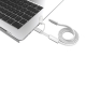 Câble de recharge blanc à gaine tressée enroulée, présenté à côté d'un ordinateur portable argenté, avec ses connecteurs USB-C e Câble de recharge blanc à gaine tressée enroulée, présenté à côté d'un ordinateur portable argenté, avec ses connecteurs USB-C e