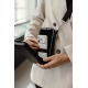 Femme plaçant un smartphone dans le compartiment intérieur de son étui de voyage porté en bandoulière, avec une bande élastique Femme plaçant un smartphone dans le compartiment intérieur de son étui de voyage porté en bandoulière, avec une bande élastique