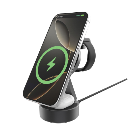 Smartphone en charge sans fil sur le support incliné, avec une montre connectée fixée à l'arrière, un boîtier d'écouteurs posé s