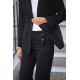 Une femme en tailleur noir soulève le pan de sa veste pour montrer une alarme d'urgence noire suspendue à un passant de son pant Une femme en tailleur noir soulève le pan de sa veste pour montrer une alarme d'urgence noire suspendue à un passant de son pant