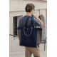 Homme portant à l'épaule un grand sac shopping bleu marine et marron, avec ses longues anses et ses poignées courtes visibles su Homme portant à l'épaule un grand sac shopping bleu marine et marron, avec ses longues anses et ses poignées courtes visibles su