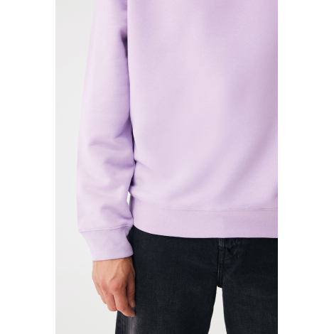 Gros plan sur le bas d'un sweat lilas porté avec un pantalon noir, montrant la texture lisse du tissu, la bande en bord-côte à l