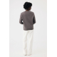 Une femme photographiée de dos porte un sweat gris taupe à col rond, avec une couture en demi-lune sous l'encolure et une bande Une femme photographiée de dos porte un sweat gris taupe à col rond, avec une couture en demi-lune sous l'encolure et une bande