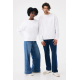 Une femme et un homme posent côte à côte, vêtus de sweats blancs unis à col rond et manches longues, associés à des jeans bleus Une femme et un homme posent côte à côte, vêtus de sweats blancs unis à col rond et manches longues, associés à des jeans bleus