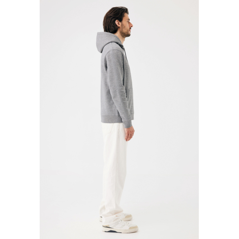 Un homme photographié de profil porte un sweat à capuche gris chiné, avec poche kangourou, manches longues et finitions en bord-