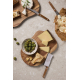 Deux plateaux en bois accueillent différents fromages, des olives et du pain sur une table en pierre claire. Les couteaux à from Deux plateaux en bois accueillent différents fromages, des olives et du pain sur une table en pierre claire. Les couteaux à from