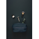 Trousse de toilette bleu marine posée sur un fond sombre, entourée d'accessoires de rasage comprenant un blaireau, un rasoir, un