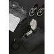 Sac de week-end noir ouvert, vu de dessus sur un fond sombre, contenant des vêtements clairs et un foulard à motifs. Un jean gri Sac de week-end noir ouvert, vu de dessus sur un fond sombre, contenant des vêtements clairs et un foulard à motifs. Un jean gri