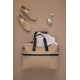 Sac de week-end extensible beige ouvert, contenant une chemise blanche, photographié de dessus sur un fond assorti. Deux mocassi Sac de week-end extensible beige ouvert, contenant une chemise blanche, photographié de dessus sur un fond assorti. Deux mocassi
