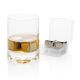 Verre de whisky ambré contenant deux glaçons réutilisables en acier inoxydable, posé à côté de leur boîte de rangement transluci Verre de whisky ambré contenant deux glaçons réutilisables en acier inoxydable, posé à côté de leur boîte de rangement transluci