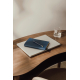 Carnet bleu marine texturé posé sur un ordinateur portable argenté, avec un stylo assorti à détails dorés sur sa couverture. L'e Carnet bleu marine texturé posé sur un ordinateur portable argenté, avec un stylo assorti à détails dorés sur sa couverture. L'e
