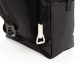 Gros plan sur l'angle inférieur du sac isotherme noir, avec décapsuleur métallique argenté suspendu à un cordon, sangle textile 