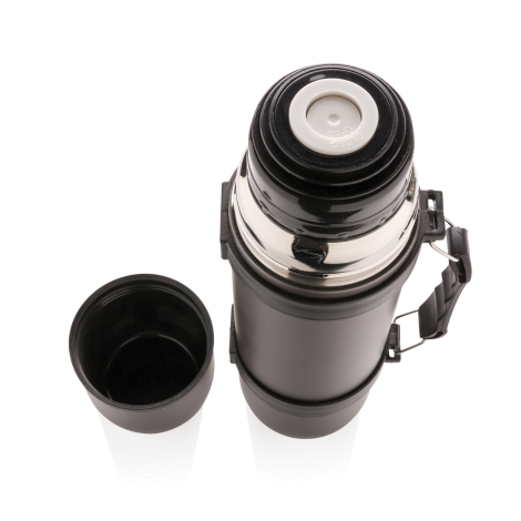 Vue plongeante sur une bouteille isotherme gris anthracite ouverte, révélant son bouchon noir à bouton central blanc entouré d'u